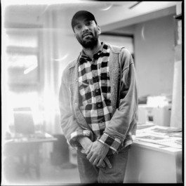  Portrait of Paul John standing in Endless Editions' studio wearing a cap and checkered flannel